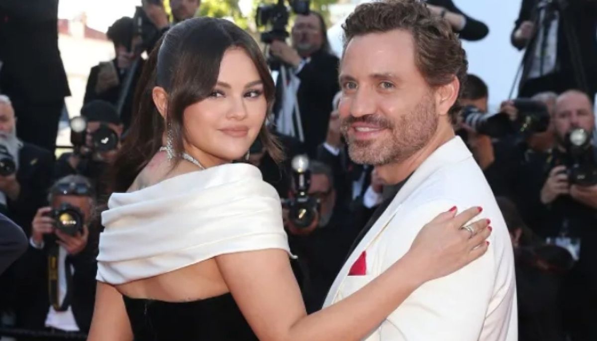 Edgar Ramirez wearing a white suit with singer Selena Gomez.